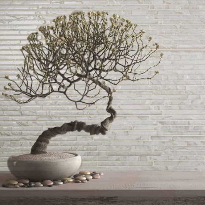 A stylized bonsai tree with intricate branches, set in a textured pot, accompanied by smooth pebbles on a minimalist surface.