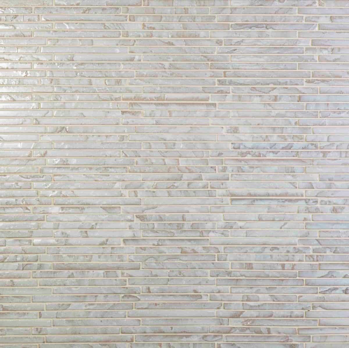 A textured wall design featuring elongated, light-colored rectangular tiles arranged in a uniform pattern.