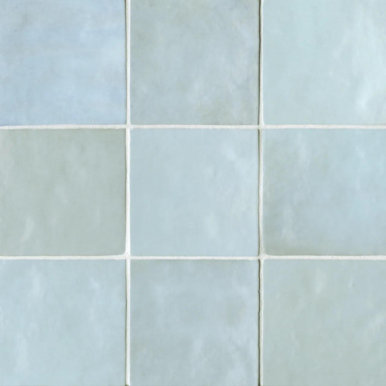 A tiled surface featuring an arrangement of light blue and gray squares with a subtle texture.