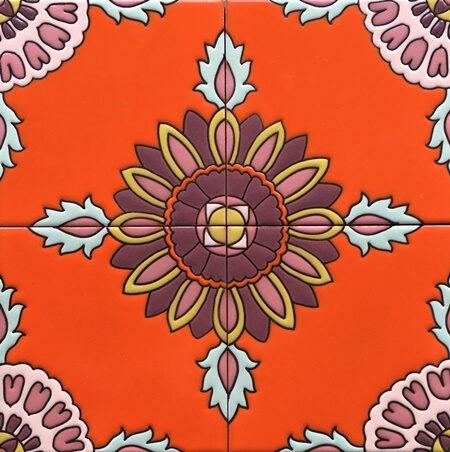A vibrant orange tile featuring a central floral motif surrounded by intricate patterns and colors, creating a lively and eye-catching design.