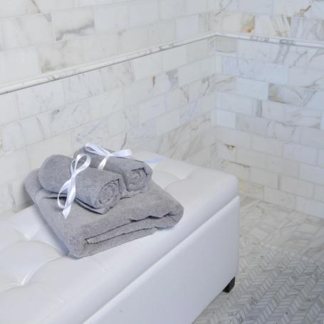 White marble-look wall tiles in modern bathroom setting.