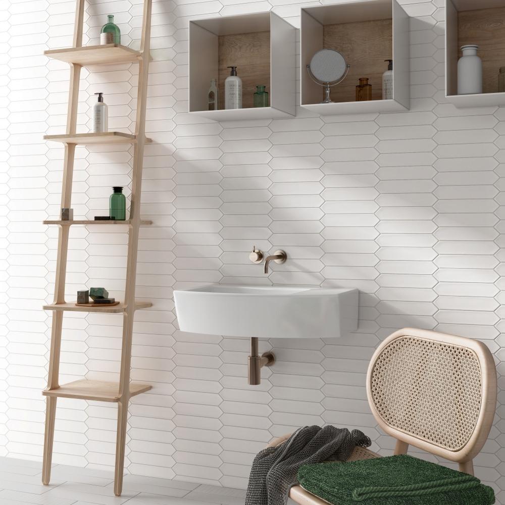 A modern bathroom interior featuring a wall-mounted sink, wooden ladder shelf, and a stylish chair, with light-colored, textured wall tiles.