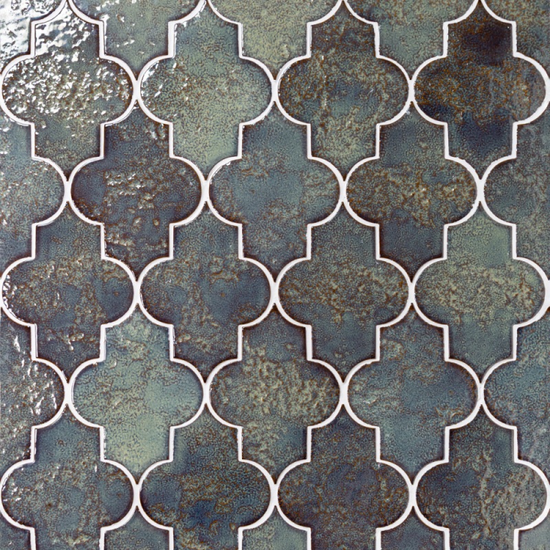 A textured tile design featuring a repetitive pattern of geometric shapes in shades of blue and green, bordered by white outlines.