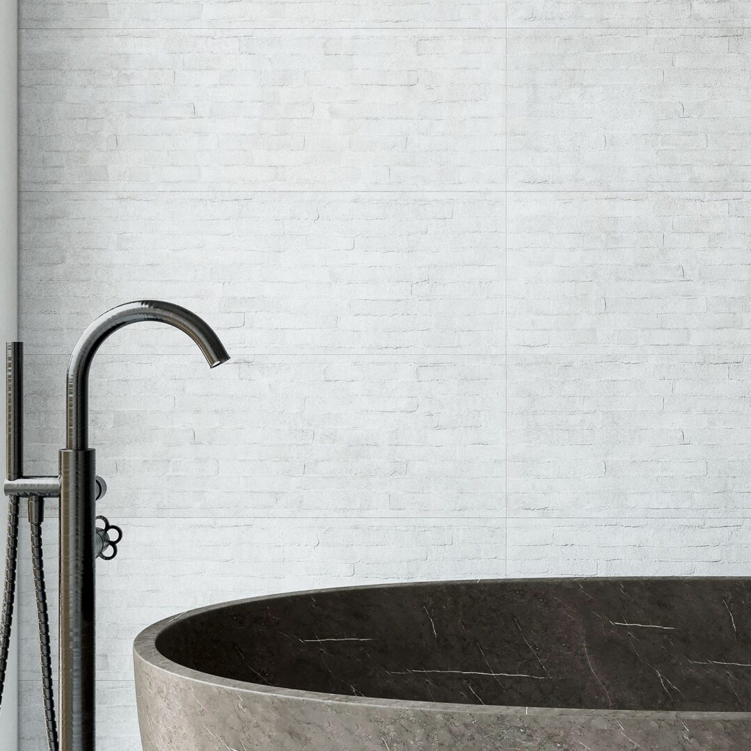 A modern bath area featuring a sleek, dark stone bathtub and a stylish faucet against a light-colored textured wall.
