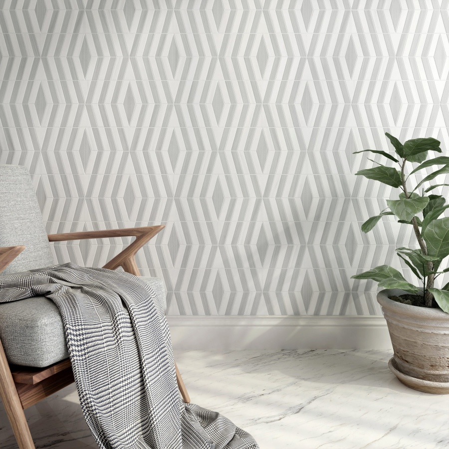 A modern chair with a blanket draped over it, beside a potted plant, against a stylish patterned wall.