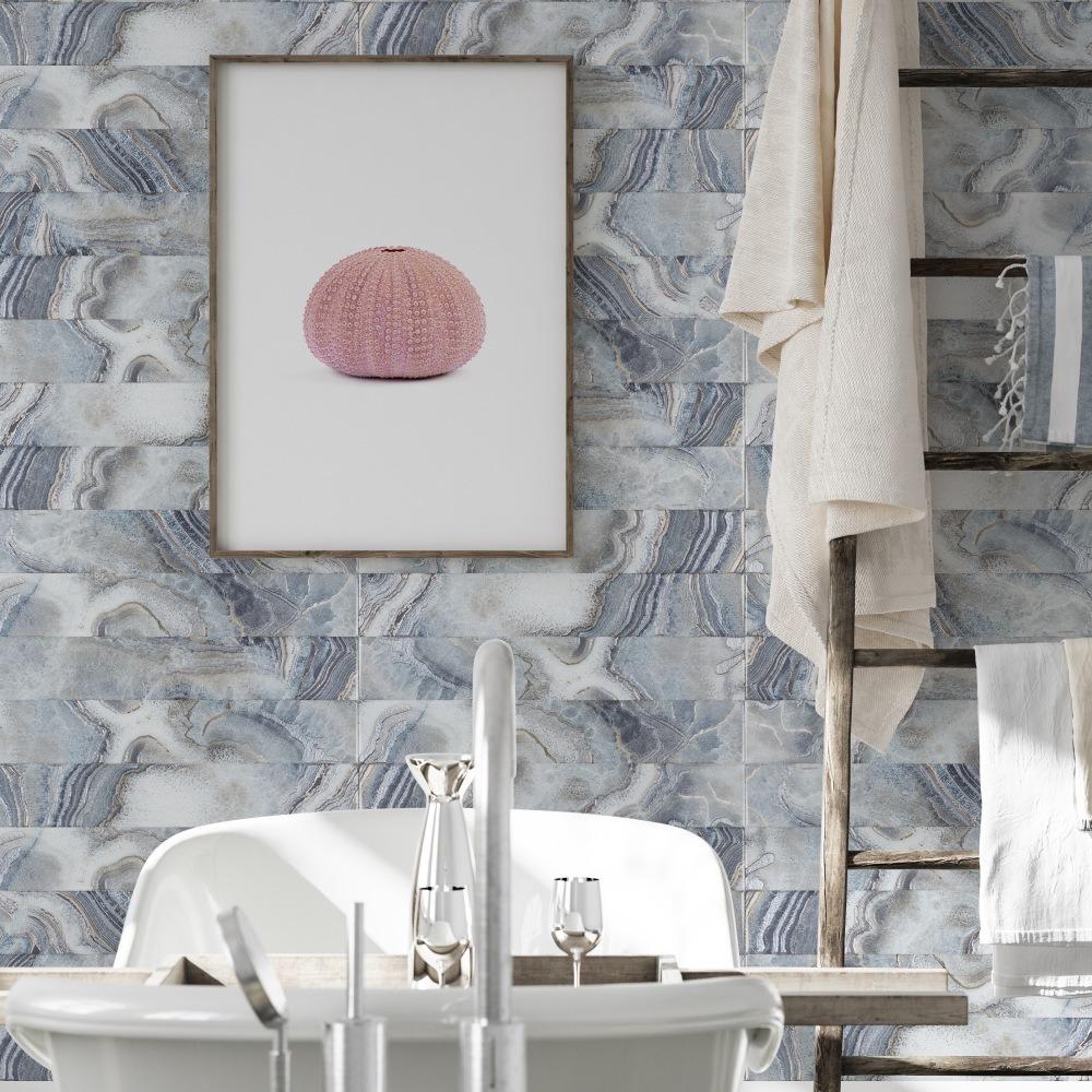 A softly decorated bathroom featuring a pink shell illustration, a white bathtub, and textured blue marble walls.