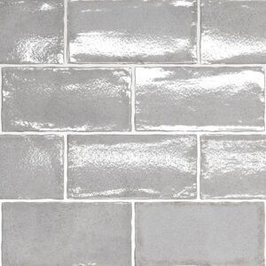 A patterned tile layout featuring glossy gray rectangular tiles with a subtle texture and varying shades.